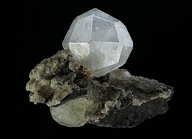 Analcime is a unique mineral that belongs to the zeolite group, which is distinguished by its porous and crystalline structure.